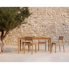 The EX 1 Outdoor Dining Chair from Ethnicraft within a courtyard next to a tree, with fruit on top of the table.