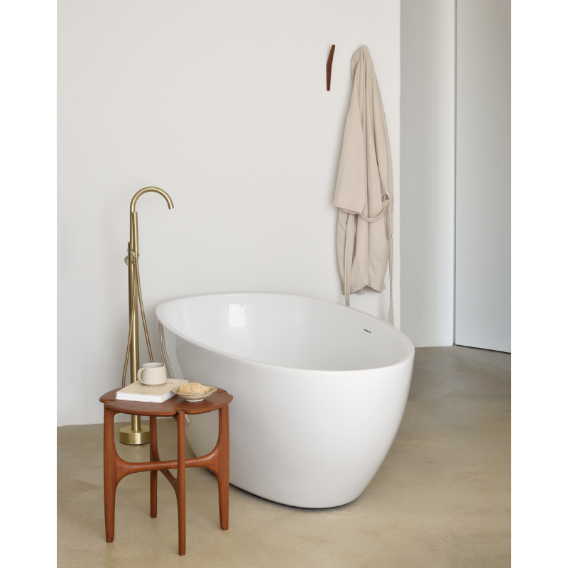 The PI Side Table from Ethnicraft within a bathroom next to the bathtub.