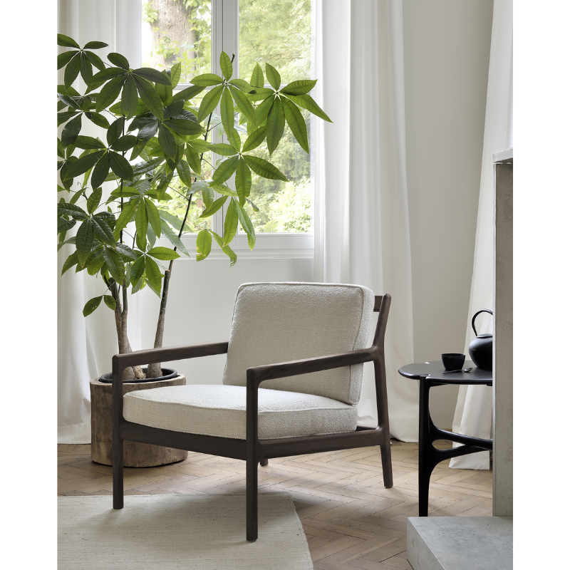 The PI Side Table from Ethnicraft in a family area beside a lounge chair and fireplace.