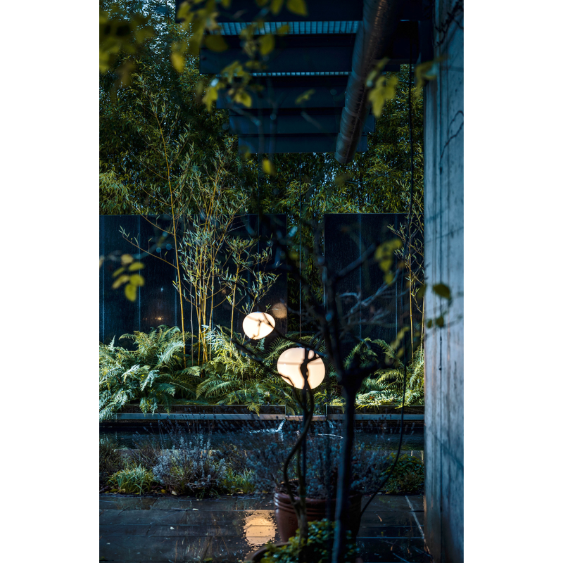 The Gregg Outdoor Pendant from Foscarini in a courtyard.