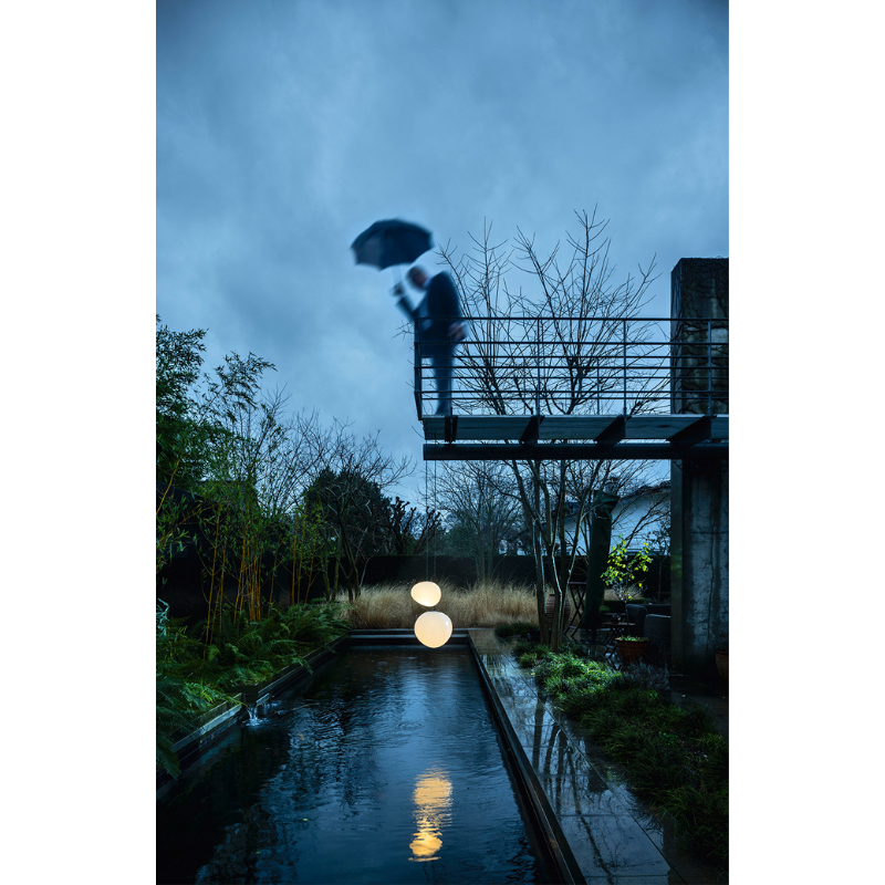 The Gregg Outdoor Pendant from Foscarini above a garden pond.