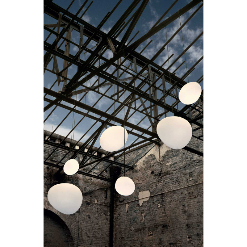 The Gregg Outdoor Pendant from Foscarini within an open space area.