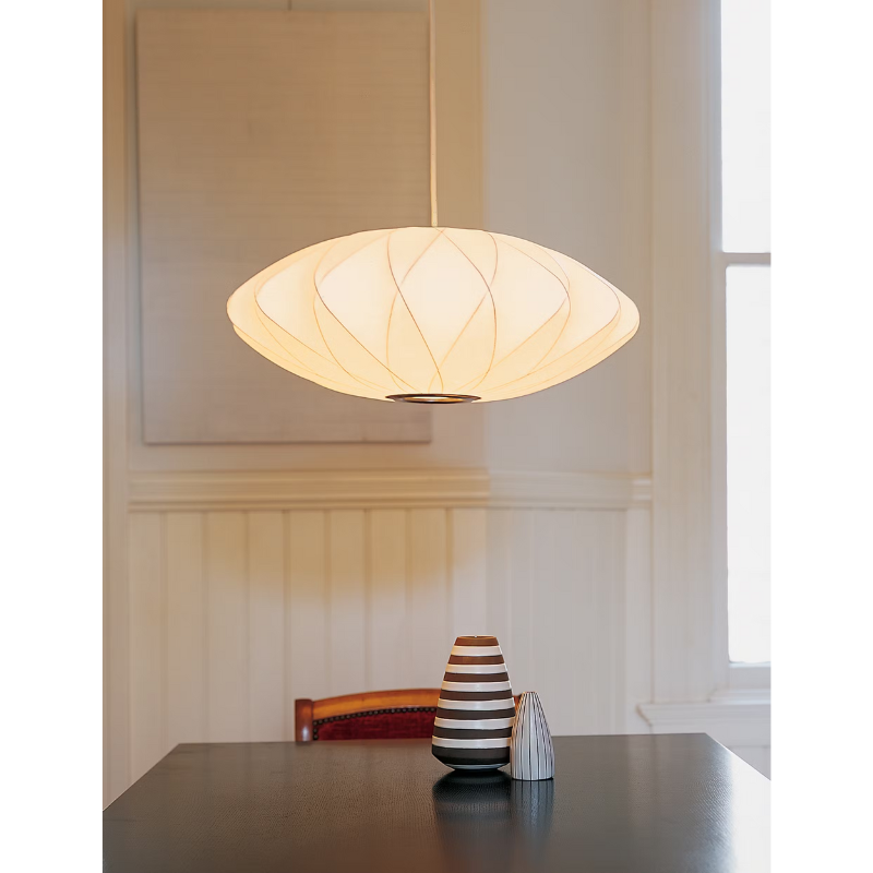 The Nelson Saucer Crisscross Bubble Pendant from Herman Miller in a dining room.