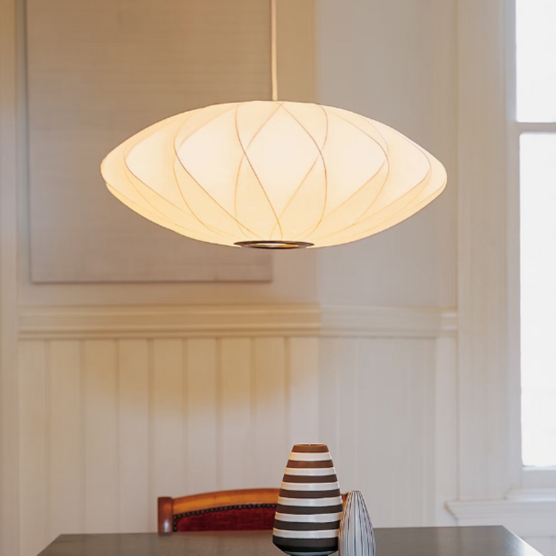 The Nelson Saucer Crisscross Bubble Pendant from Herman Miller in a dining room.