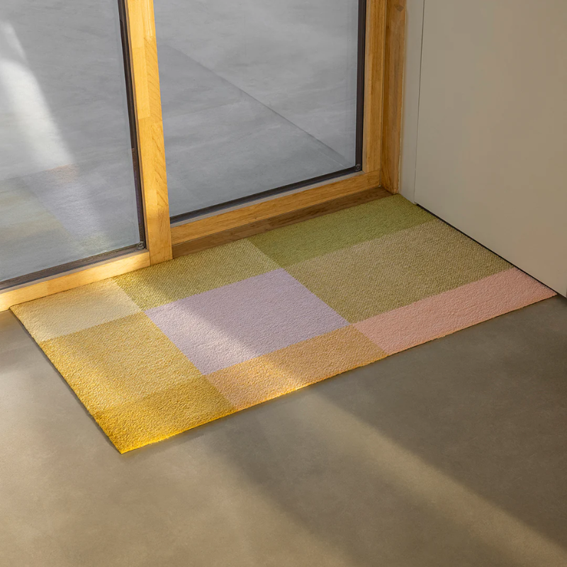 The Mix Teklan Entry Mat from Heymat in large size adorning a doorway.