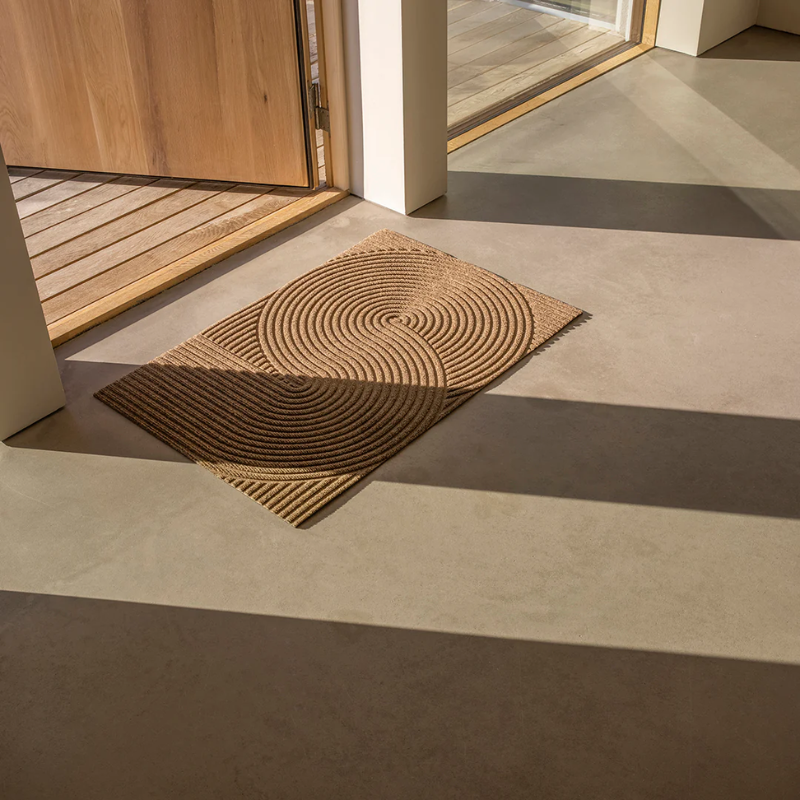 The Sand Doormat from Heymat in the small size in front of a doorway.