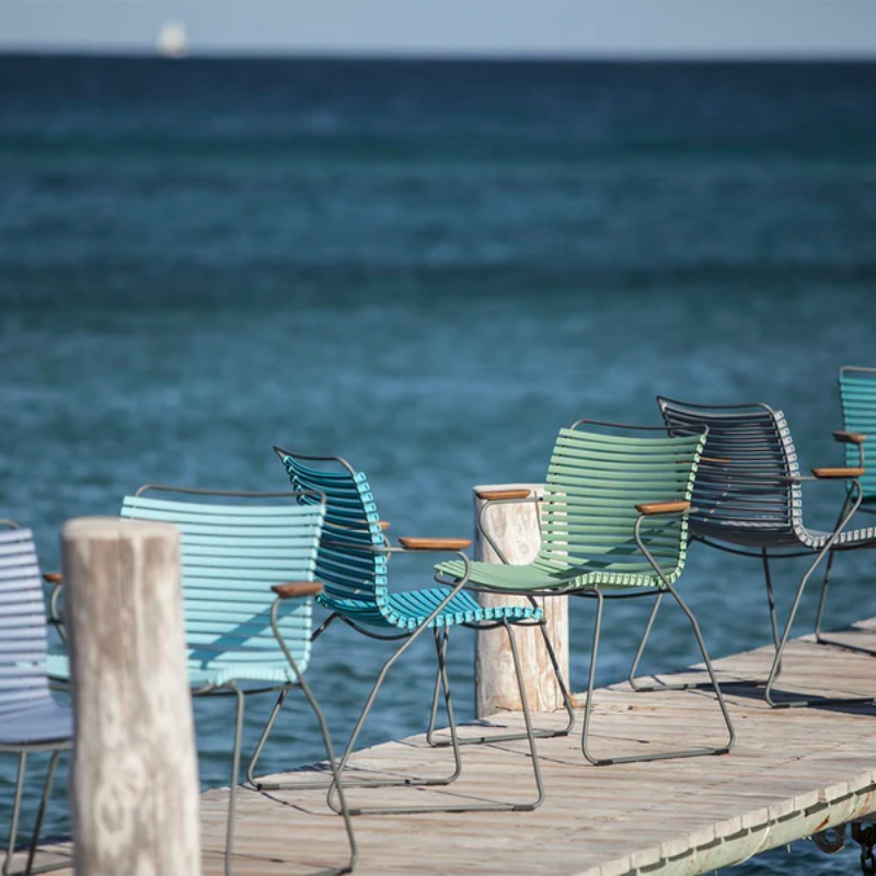CLICK outdoor dining armchair is simple, honest, and ergonomically well thought out. It is beautiful in its repetition around the table and because the slats (lamellas) can be replaced, you can mix and change the colors as often as you like. These outdoor dining chairs are stackable and easy to store.