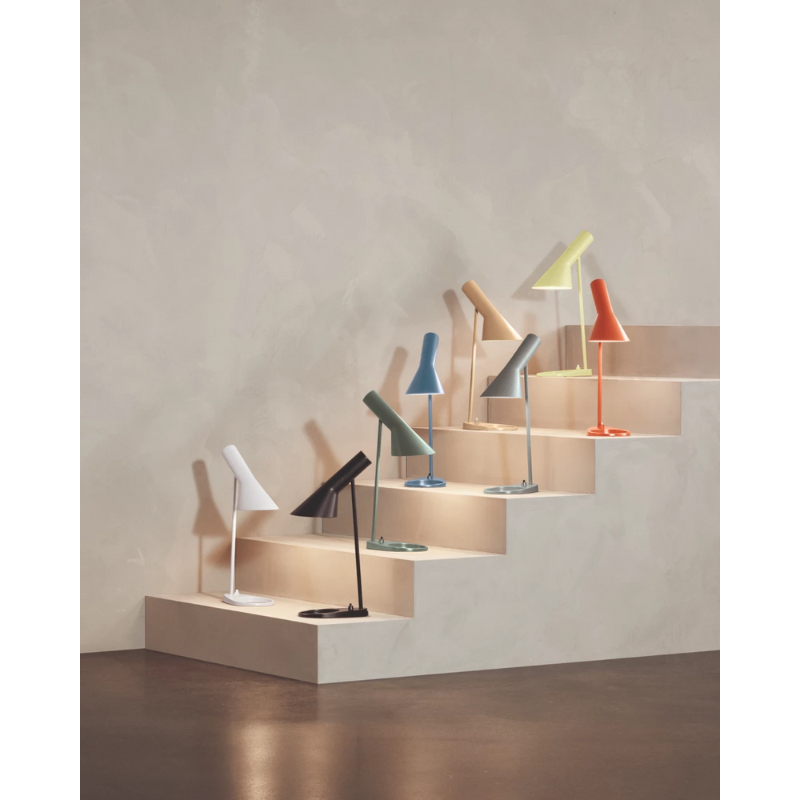 The AJ Mini Table Lamp from Louis Poulsen in a photograph highlighting the light colors within the collection. all-groups