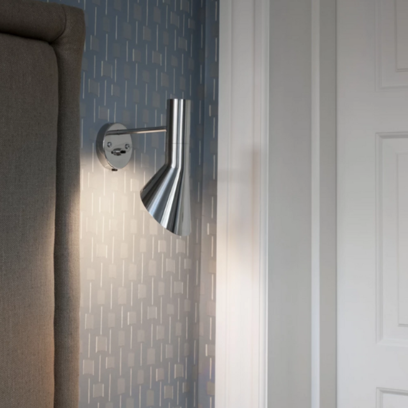 The AJ Wall from Louis Poulsen next to the entryway to a bedroom.