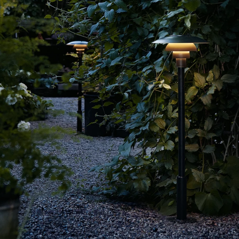 The PH 3-2½ Bollard from Louis Poulsen outdoor by a path.