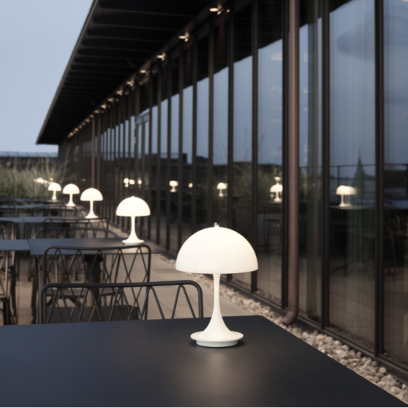 The Panthella 160 Portable from Louis Poulsen outdoors in a cafe setting.