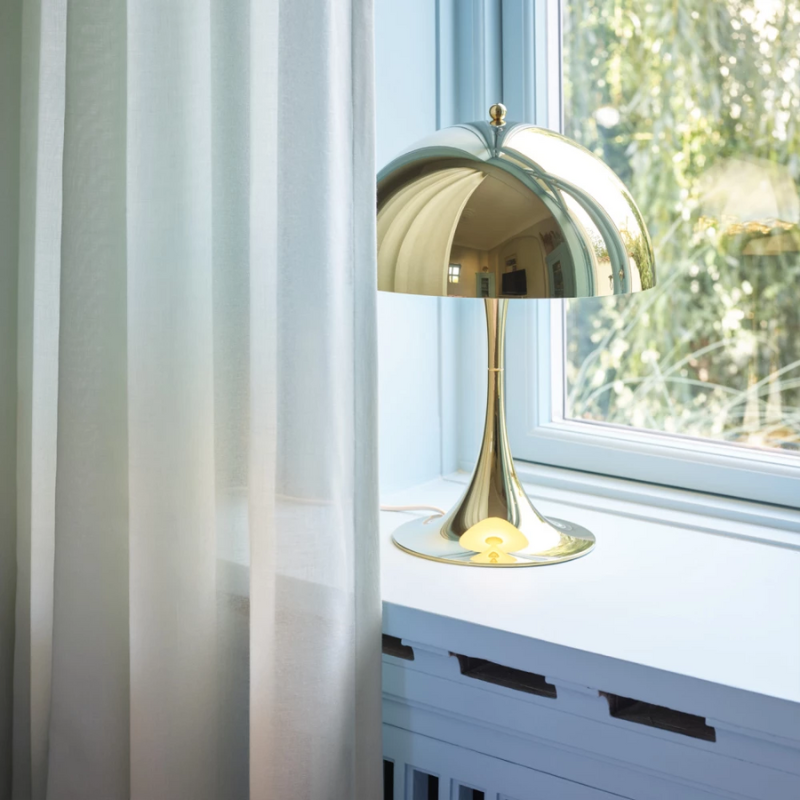 The Panthella 320 Table Lamp from Louis Poulsen in a window.