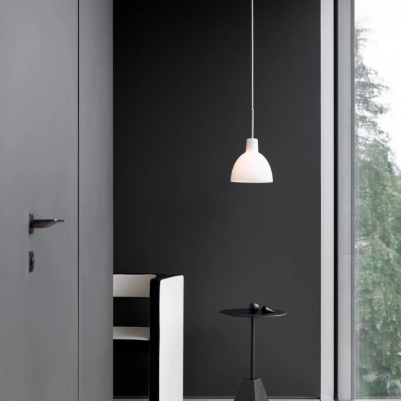 The Tolbod 6.1/8.7 Glass Pendant from Louis Poulsen in a living room.