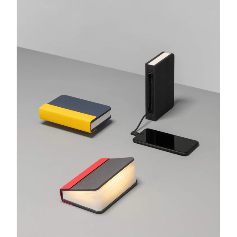 The Lito Mini from Lumio showing he multiple color options, and charging a smartphone.
