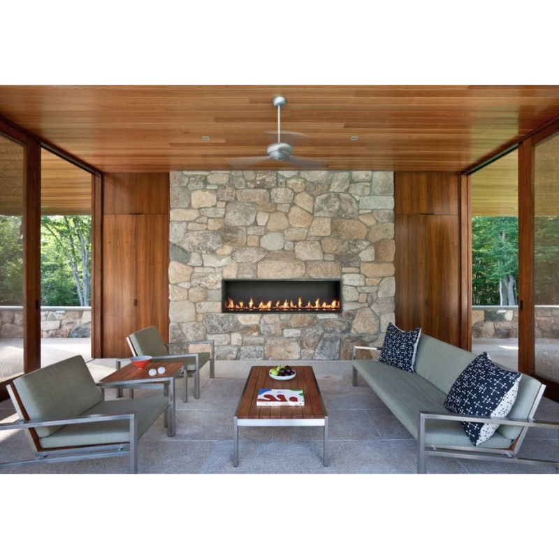 The Altus suspended ceiling fan from The Modern Fan Co. in a living room with a fireplace.