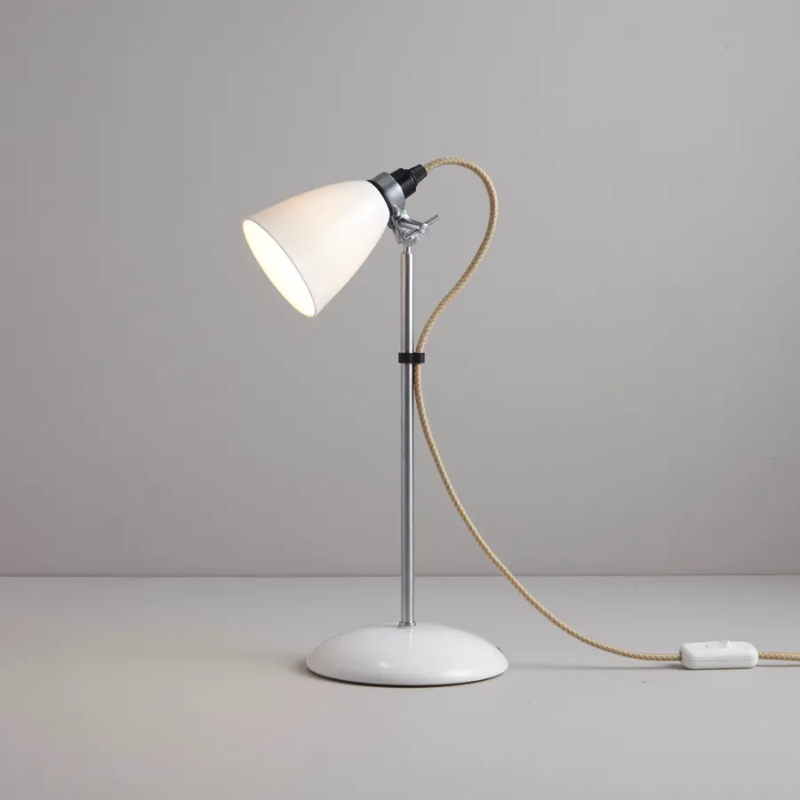 A British design classic in translucent Bone China. With its moveable shade and smart cotton braided cable, the Hector Table Light perfectly combines style and function. Available in three colors (natural white, light blue or light green) with varying sized shades.