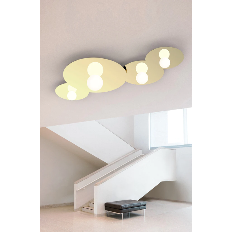 The Bola Disc Flush from Pablo Designs in brass mounted to the ceiling in various sizes creating a dazzling lighting display.