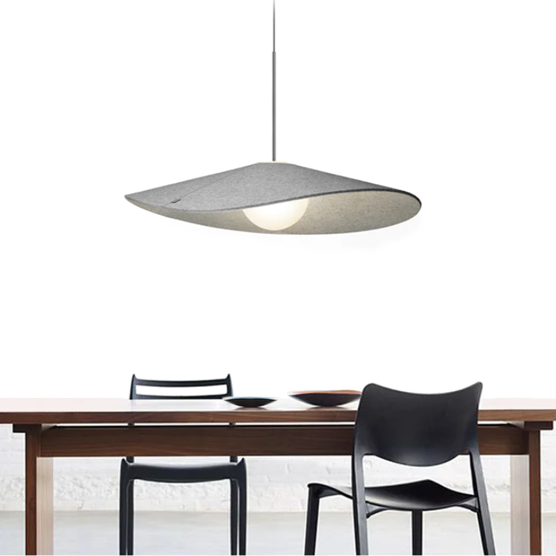 The Bola Felt from Pablo Designs suspended above a dining table in a dining room.