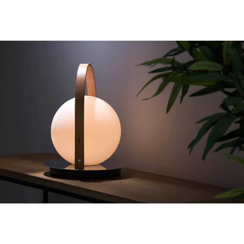 The Bola Lantern on top of a table indoors.