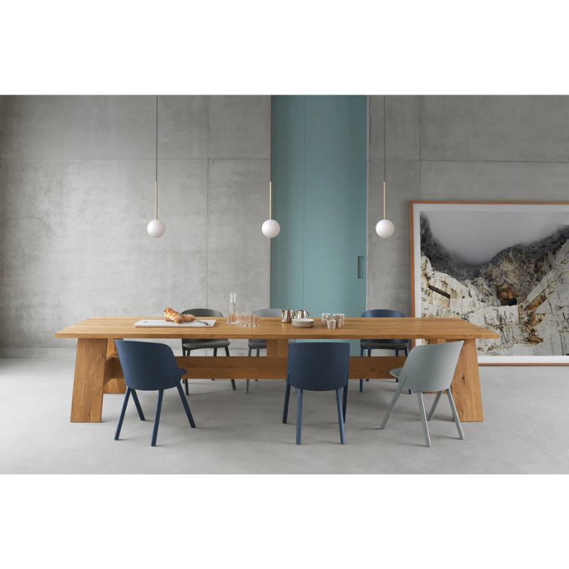 The Bola Sphere from Pablo Designs above a dining table in an open space dining room.