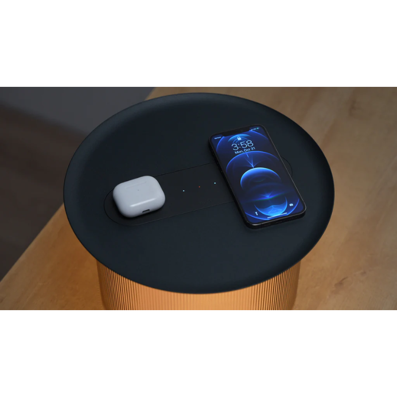 A phone and headphones charging on top of the Carousel Table using the wireless charging function.