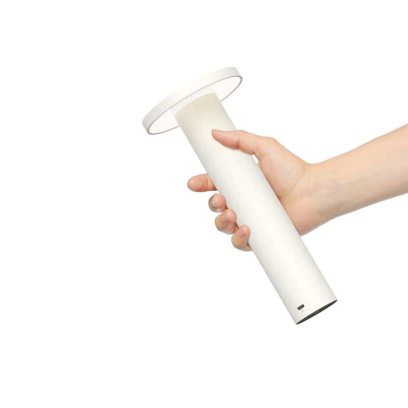 The Luci Table from Pablo Designs being held and highlighting it's portable nature.