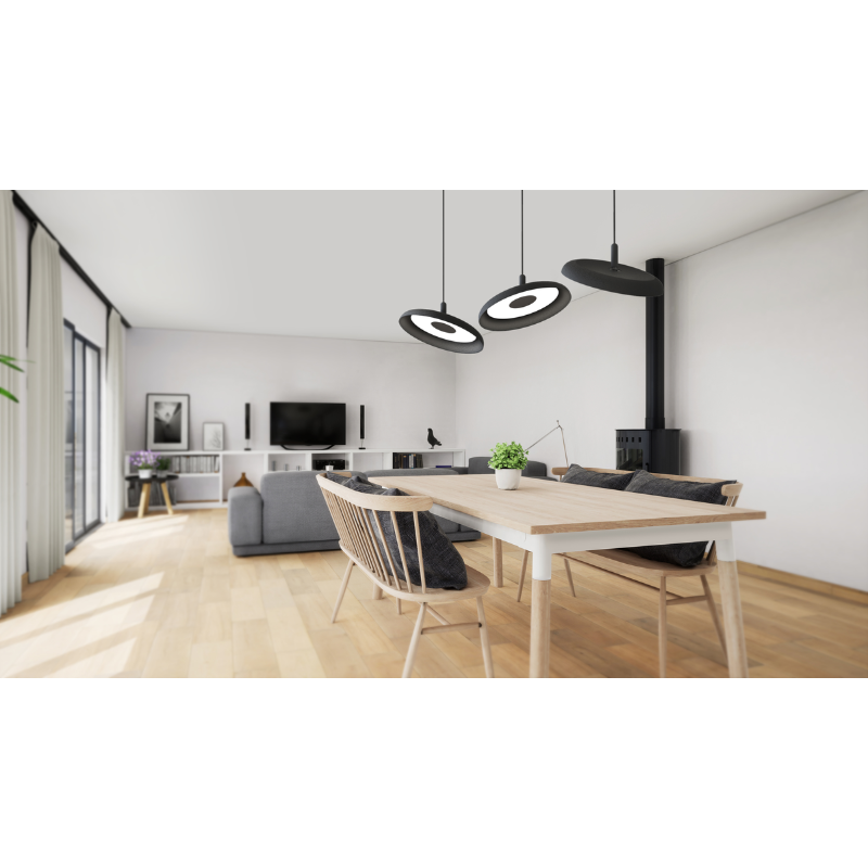 Three of the black shade, black cord Nivél Pendants from Pablo Designs suspended above a dining room table within an open living room and dining space.