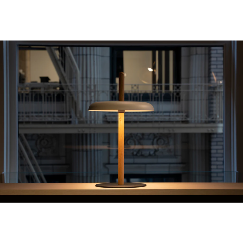 The Nivél Table from Pablo Designs on a countertop next to a window.