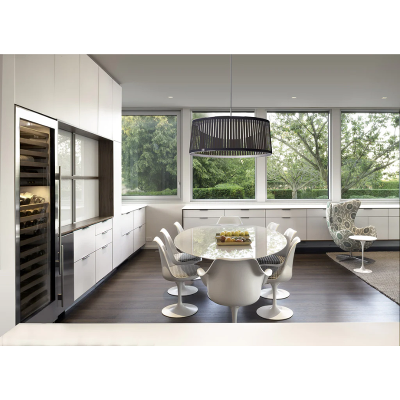 The Solis Drum from Pablo Designs above a dining table within a dining room.