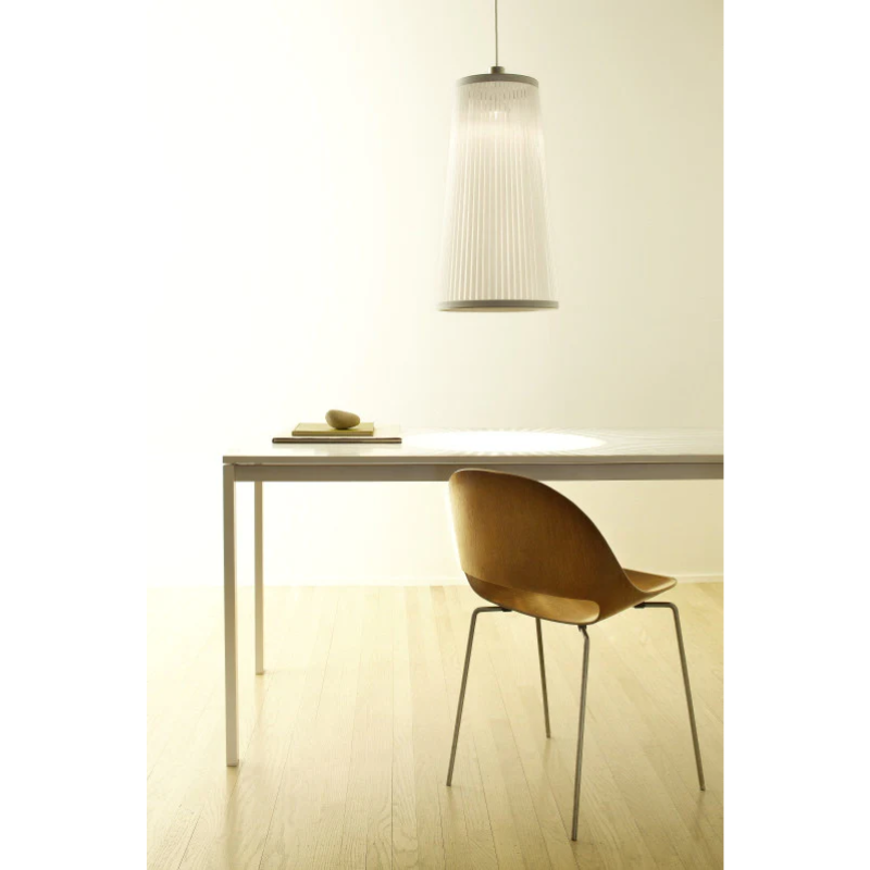 The Solis Pendant from Pablo Designs suspended above a table within a living space.