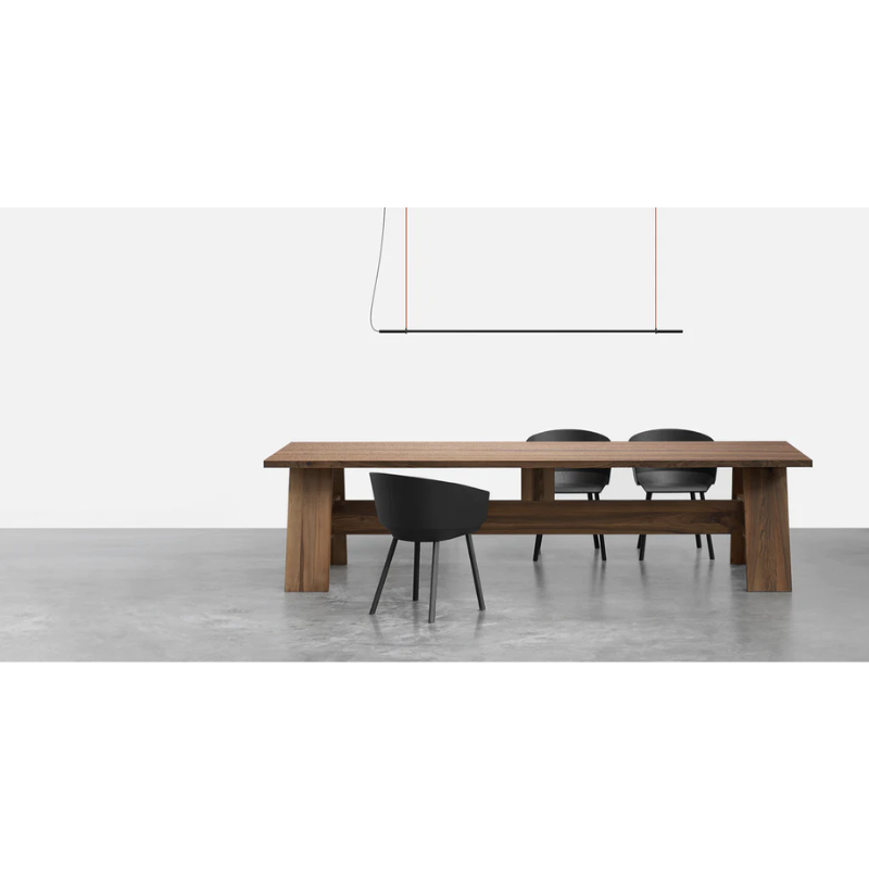 The T.O Pendant from Pablo Designs above a dining table within a dining room.