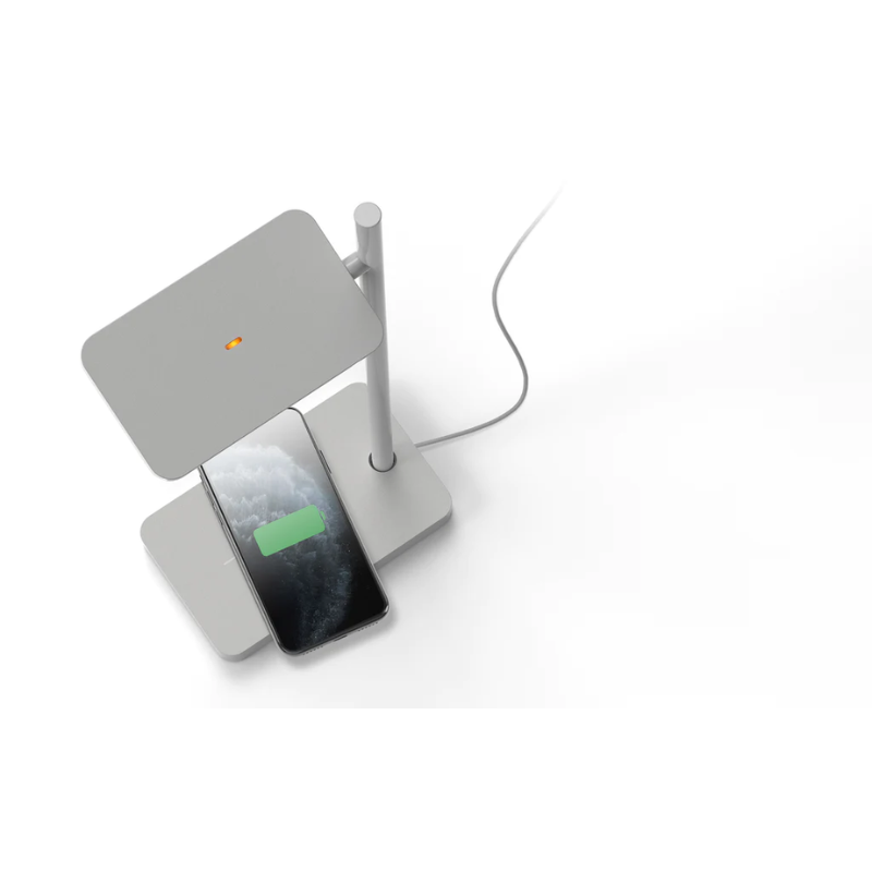 The Talia Table from Pablo Designs being shown charging a cellphone with the wireless charger.