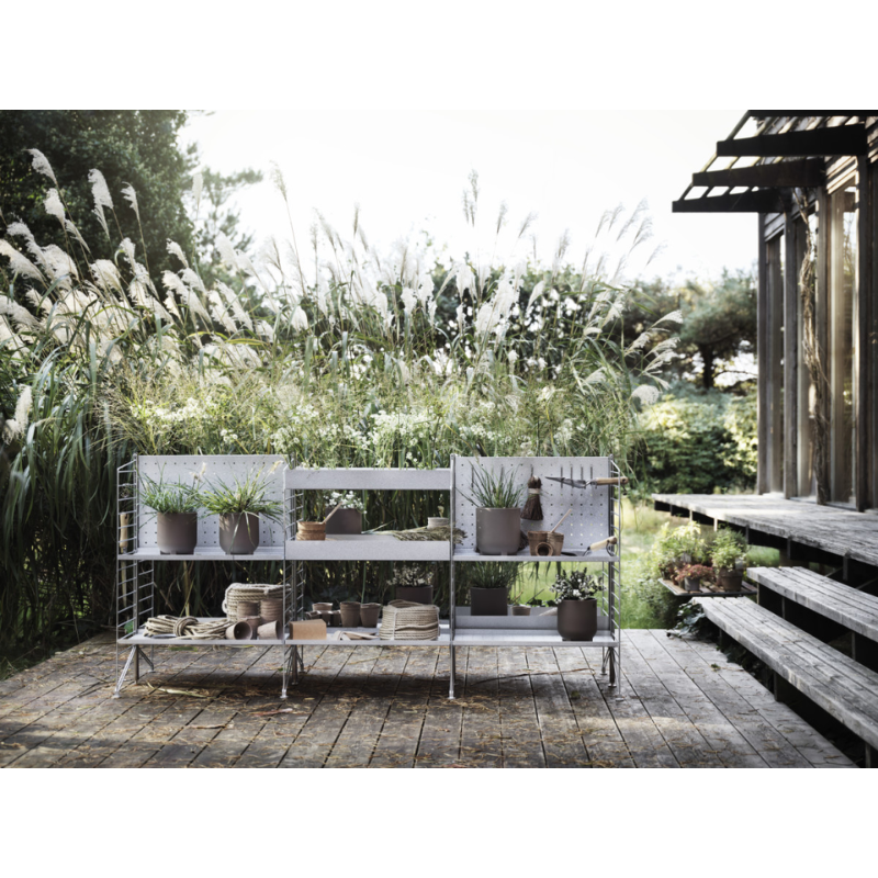 The Back Panel Galvanized from String Furniture in an outdoor lounge.