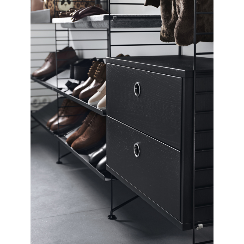 The Chest of Drawers from String Furniture in a wardrobe within a closet.