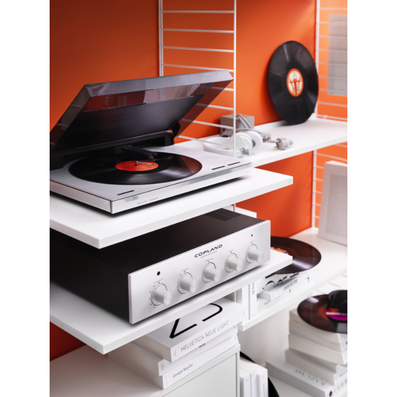 The Media Shelf from String Furniture in a lifestyle shot holding music accessories and decor.