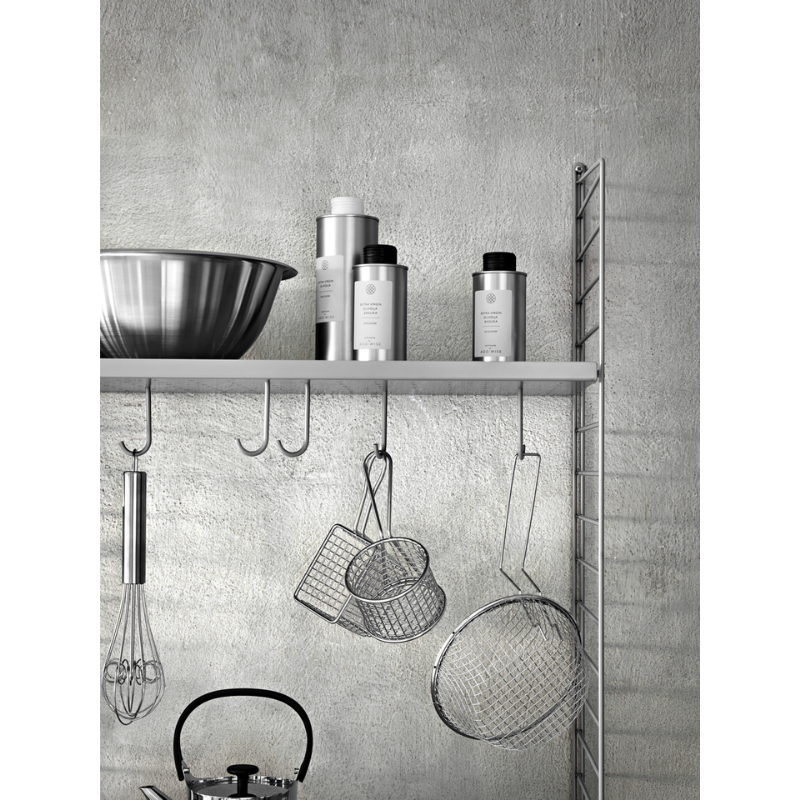 The Metal Shelves Low from String Furniture being used to hold decor and utensils.