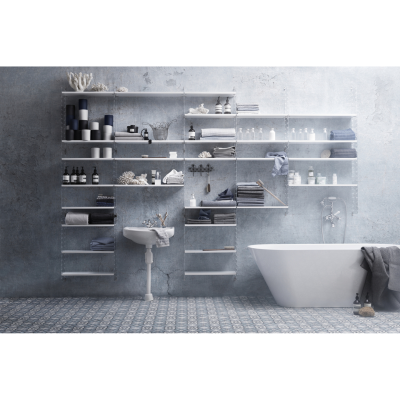 The Shelves from String Furniture beside a bath.