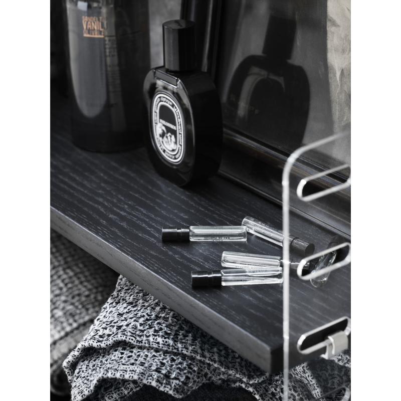 The Shelves from String Furniture holding household goods such as perfume, cologne and wash towels.