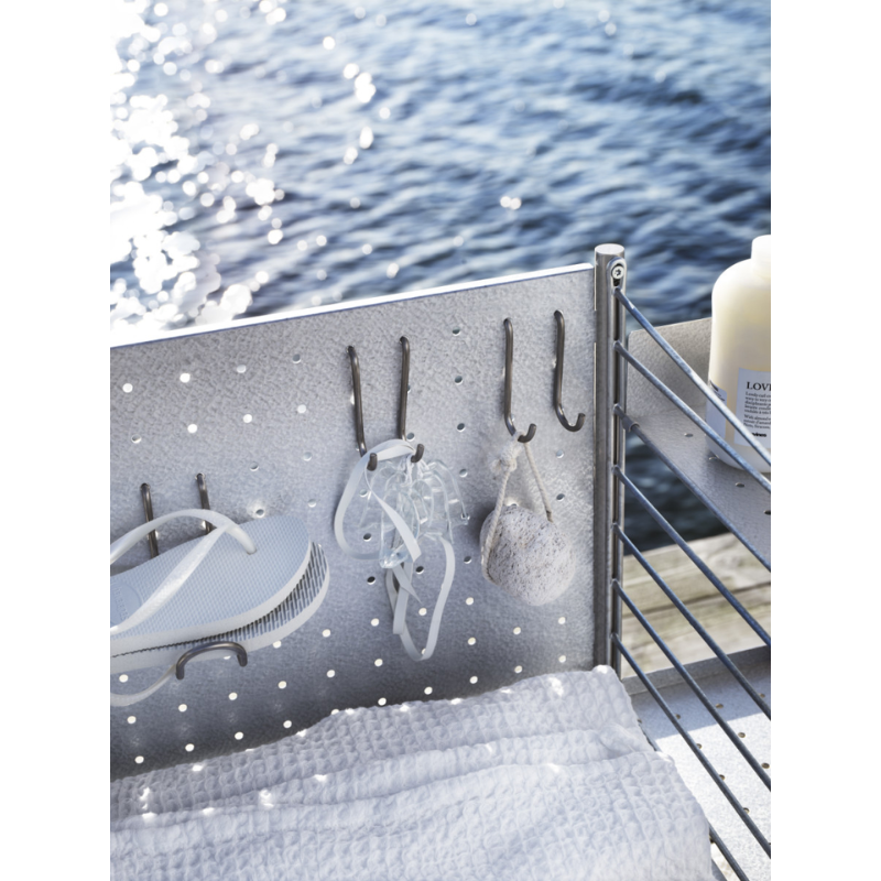 The Vertical Hook from String Furniture outdoors by a lake.