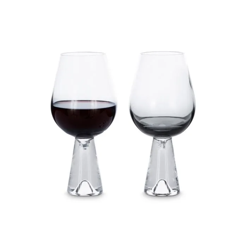 A set of two Tank Wine Glasses in Black from Tom Dixon being shown with one filled with red wine, and the other empty.