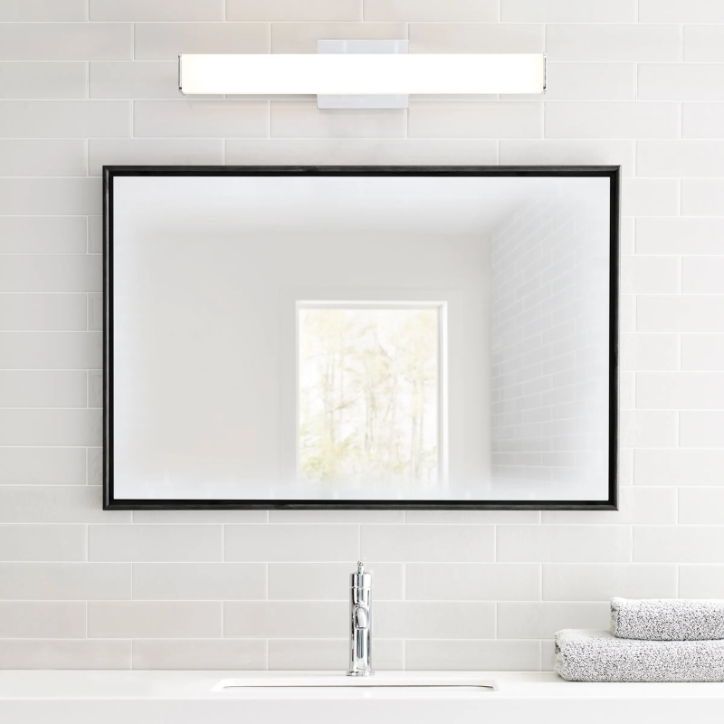 The Lynn Bathroom Sconce from Visual Comfort and Co being used as a vanity light above a mirror.