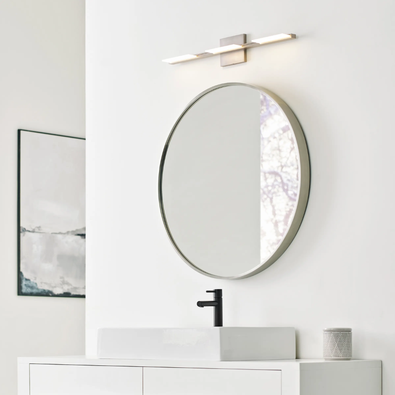 The Tris 3-Light Bathroom Sconce from Visual Comfort and Co above a sink being used as a vanity light.