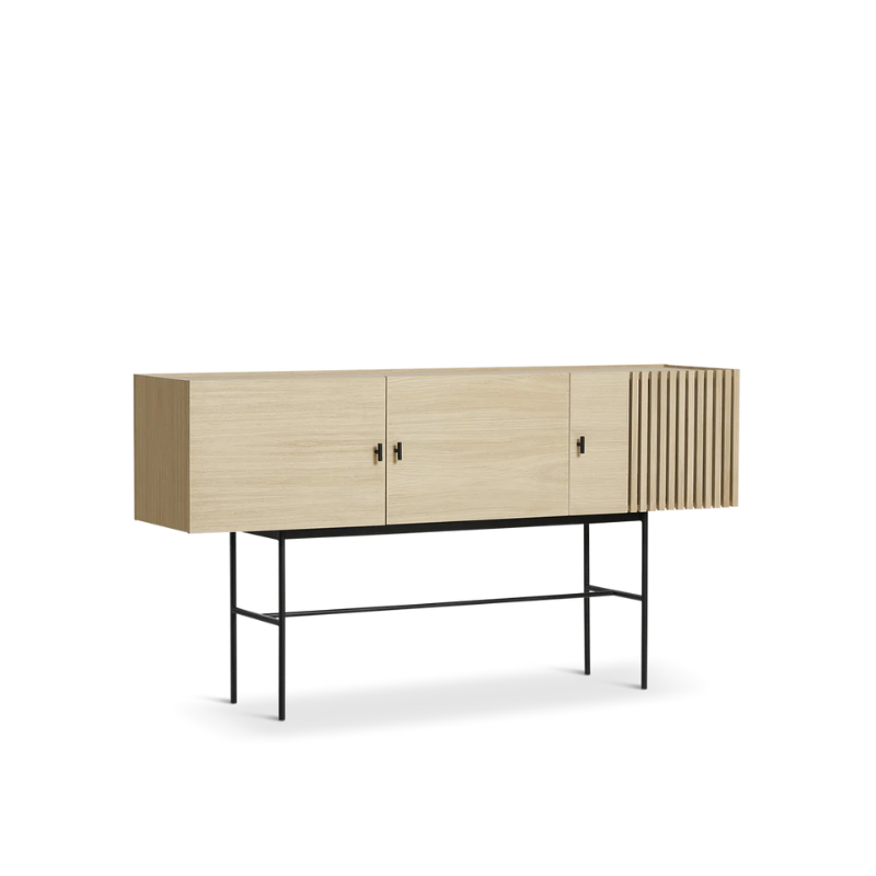 The Array series is inspired by the wooden slate cladding found in modern architecture. With its geometric shape and horizontal slats, it creates a strong visual effect from catching both light and shadow in the depth of the slats. The sleek legs lift the sideboards from the ground creating an elegant contrast between the solid wooden cabinet on top and the thin metal construction underneath. Soft closing doors make the cabinet both functional and delicate.
