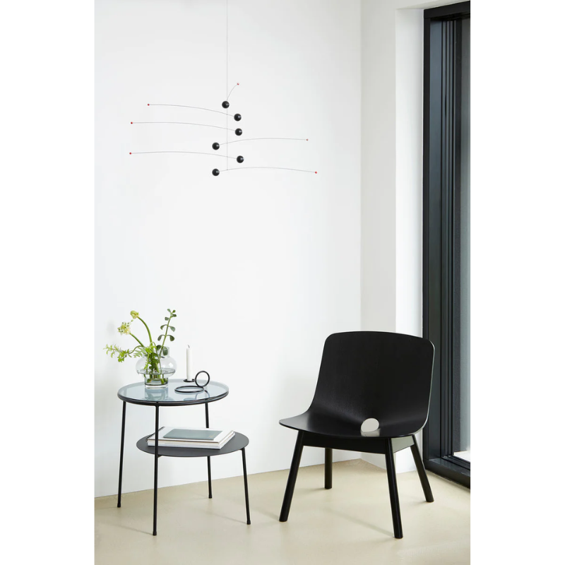 Duo Side Table from Woud within a family space with a plant and books on top.