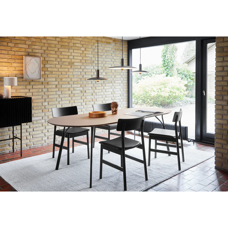 The beige and black large Tree Dining Table from Woud in a modern dining setup.