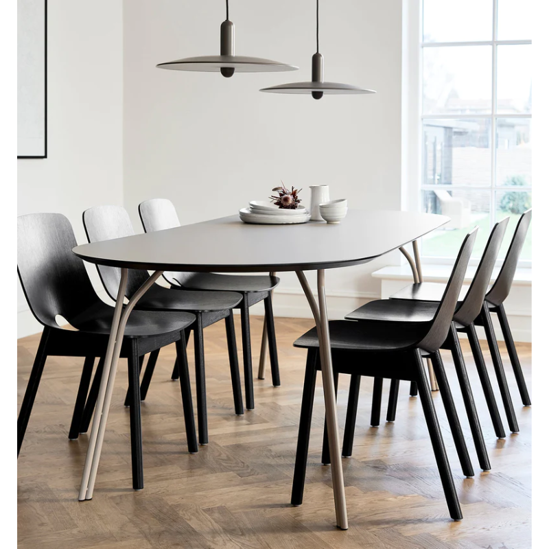The large beige Tree Dining Table from Woud with 6 seats, 3 either side.