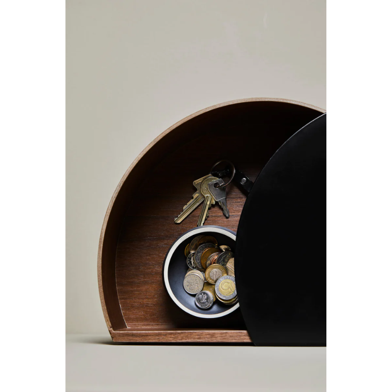 Wallie beautifully combines bent walnut with solid black metal creating an elegant wall-mounted drawer. With its circular, soft shapes Wallie is a visually strong design that easily can act as a centerpiece or be combined with other designs. The bracket embraces the magnetic wood drawer making the design both minimalistic and functional. Wallie is perfect for storing small everyday essentials in the hallway or as a bedside table in the bedroom.