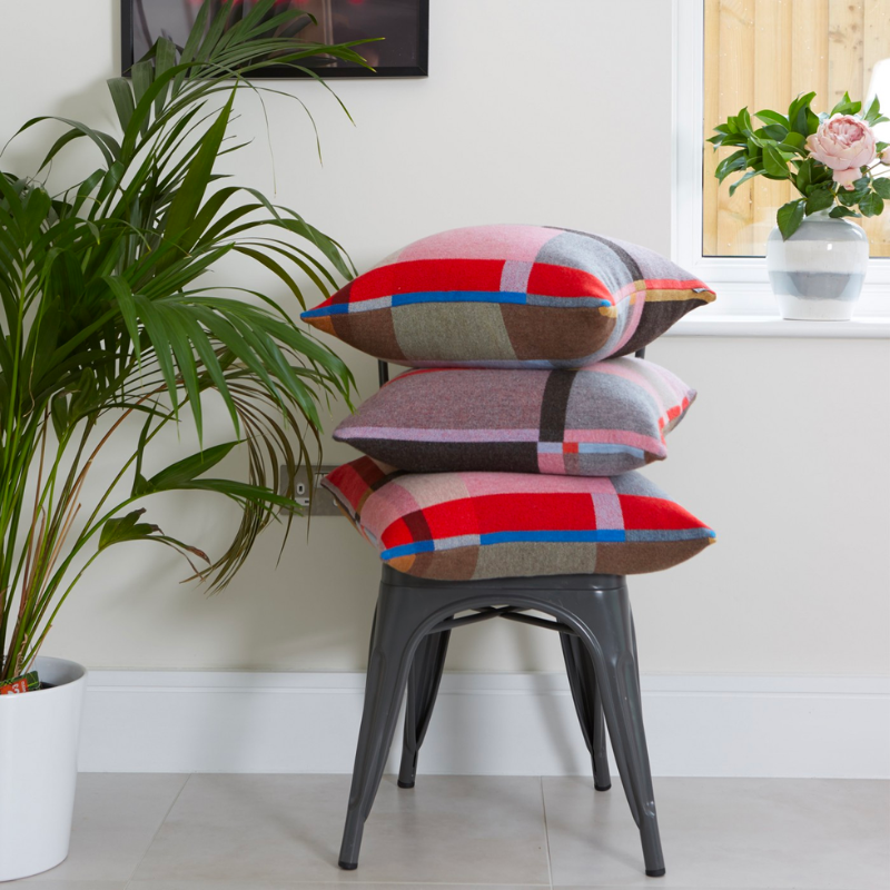 Lasdun Lambswool Block Cushion on a chair.