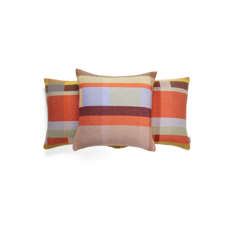 The Cecil Cushion features bold checkerboard blocks inspired by Chung Eun Mo, woven in soft merino lambswool with a reversible design and vibrant colorways. Trio of cushions shown.