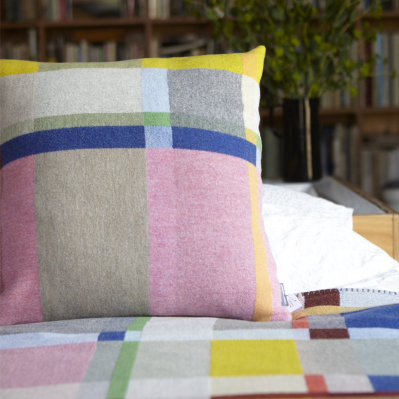 The Lloyd Cushion from Wallace & Sewell on a bed.